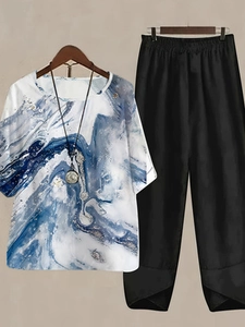 Detail of blue marble print top and black wide-leg trousers with tulip hem design