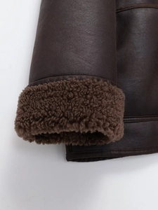 Dettaglio delle doppie cuciture sul polsino della giacca in shearling marrone