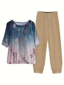 Detail of floral print top with gradient blue design and unique cross-cut hem khaki pants