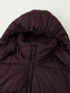 Detail of hooded winter puffer jacket featuring dark red windproof fabric and silver zipper