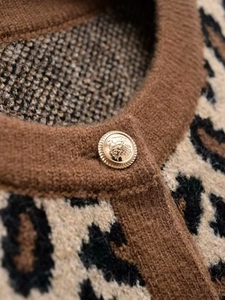 Detailansicht der goldenen Löwenkopf-Knöpfe an der Strickjacke mit Leopardenmuster