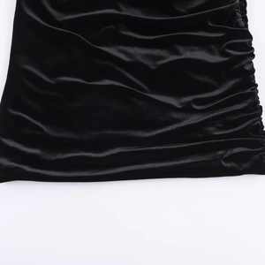 Detailaufnahme aus schwarzem Samt mit eleganten seitlichen Raffungen und Faltenwurf