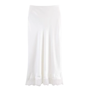 Dettaglio gonna midi in raso bianco con orlo in pizzo elegante e trama setosa