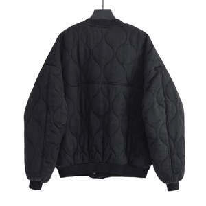 Detail view of the quilted bomber jacket featuring wave stitching and ribbed cuffs