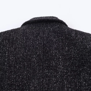 Detail of black tweed jacket featuring metallic silver threads and woven collar texture