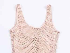 Détail de paillettes or rose en motif V sur une robe de cocktail en tulle rose