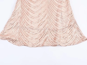 Détail de paillettes or rose cousues en motif de V sur une élégante robe de soirée