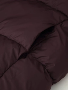 Close-up of quilted burgundy winter jacket showing silk texture and side pocket