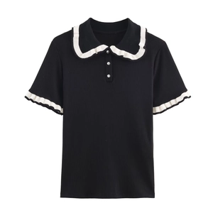 Detail of black ribbed knit top with white ruffled polo collar and rhinestone buttons