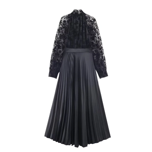 Detail of elegant black long sleeve dress featuring floral lace and pleated satin fabric