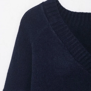 Close-up of the ribbed V-neckline and fine knitted texture on this navy blue sweater