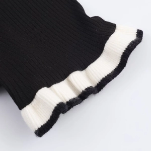 Detail of black and white contrast ribbed knit fabric with ruffle edge on a slim t-shirt