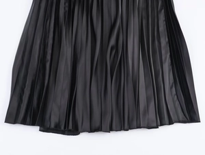 Detail of high-density pleated black satin skirt fabric with elegant glossy finish