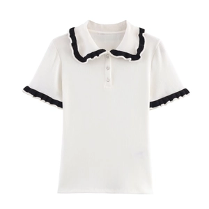 Detail of white knit polo shirt with black ruffled trim and crystal buttons