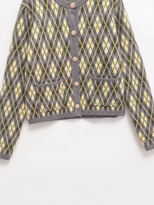 Detail of the argyle knit cardigan with gray and yellow patterns and metal buttons