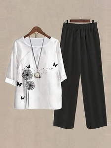 Detail of white cotton-linen top with black dandelion print and black wide-leg trousers