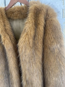 Detailed view of dark brown faux fur coat showing thick texture and silk lining
