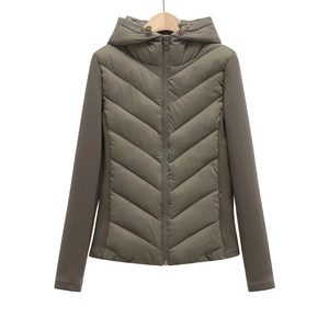 Detail view of the quilted front and smooth contrast sleeves on the green hooded jacket