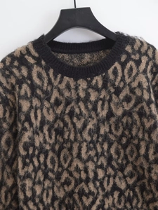 Detail view of leopard print knit sweater with fuzzy texture and ribbed crew neck