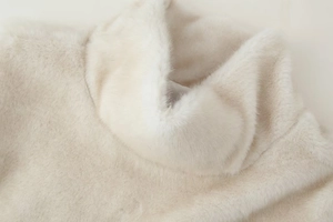 Detailed macro view of the ivory faux fur collar with soft synthetic fiber texture
