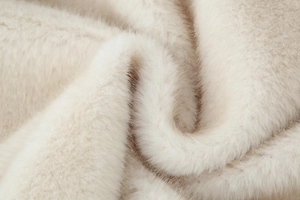 Macro shot of high-quality faux fur material in creamy white with soft fluffy texture