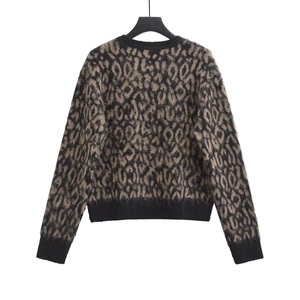 Detailed view of leopard print knit sweater featuring black ribbed cuffs and neckline