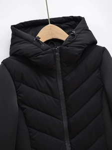 Detail of black hooded jacket with V-quilted pattern and patchwork sleeve design