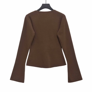 Detail of dark brown knit sweater featuring elegant chest pleats and flared sleeve cuffs