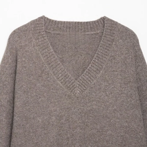 Detail view of ribbed V-neckline on soft coffee brown knit sweater with fine texture
