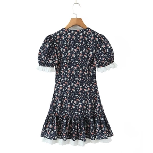 Detail of floral mini dress featuring lace trims and puff sleeves on white background