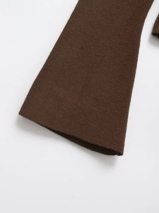 Detail of flared cuffs on dark brown knit sweater showing fine ribbed texture
