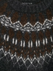 Detailed view of Fair Isle geometric jacquard knit pattern on a dark grey wool sweater