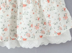 Close-up of floral print fabric with delicate white lace embroidery trim on mini dress