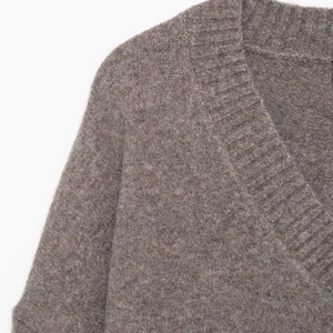 Detail of the V-neckline and soft ribbed texture on this brown knit sweater for women