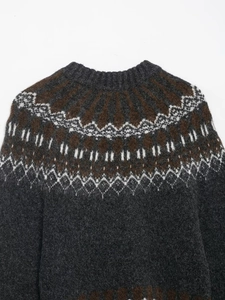 Close-up of Fair Isle pattern knit sweater with grey wool texture and ribbed neckline