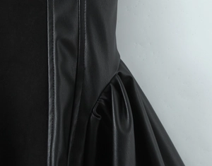Vue détaillée des coutures verticales et du plissé sur une robe en similicuir noir