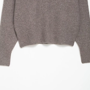 Detailed view of the ribbed cuff and hem on this soft dark brown knit sweater
