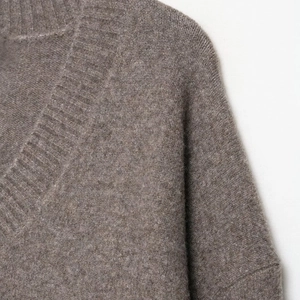 Detail shot of the V-neckline and soft fuzzy knit texture of this coffee brown sweater