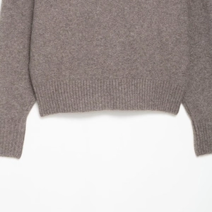 Close-up of the ribbed knit hem and cuffs on a soft coffee-colored cashmere wool sweater