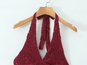 Detail of burgundy sequined mesh dress showing halter neck with a wide ribbon bow tie