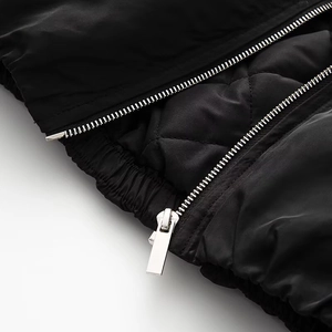 Detail of silver zipper, elastic hem and quilted lining on black winter jacket