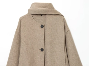 Detail view of khaki wool coat fabric texture and large black buttons on the front