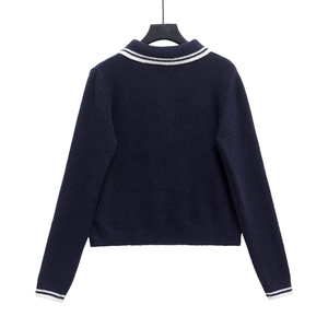 Navy blue long sleeve knit sweater with white striped collar and cuffs shown from back view