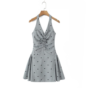 Detail of grey halter dress featuring a 3D rose accent and velvet bow patterns