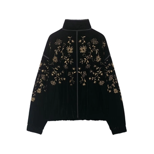 Detailansicht goldener Stickerei auf einer schwarzen Samtjacke mit Stehkragen