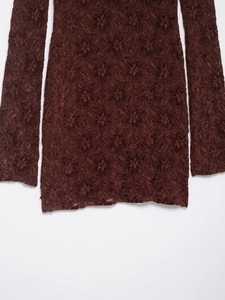 Macro shot of burgundy floral lace texture and intricate hollow detailing on the dress