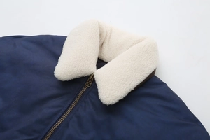 Détail du col en fausse fourrure blanche amovible et fermeture éclair sur veste bleu foncé