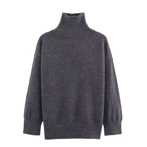 Detail view of dark grey turtleneck sweater with ribbed cuffs and knitted texture