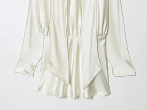 Detailed macro of pearl white silk satin texture with elegant draped scarf neck tie