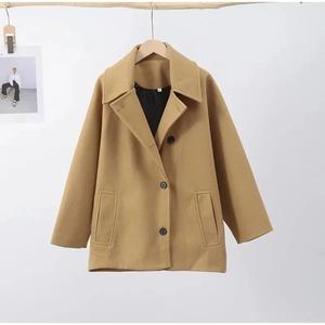 Détail de la veste en laine camel avec revers et boutons noirs sur cintre en bois